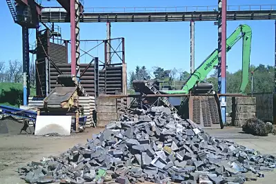 Ein Haufen Metallschrott liegt vor einer Maschine in einer industriellen Umgebung.